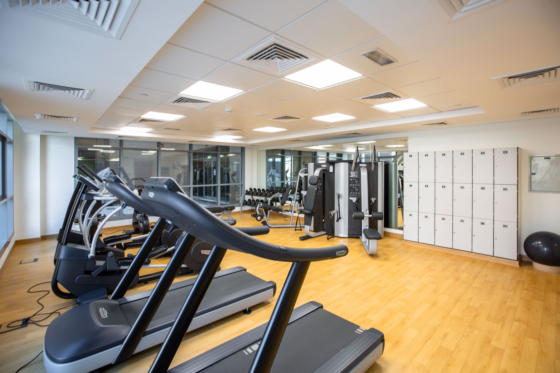 Spacious gym interior featuring treadmills, fitness machines, and lockers.